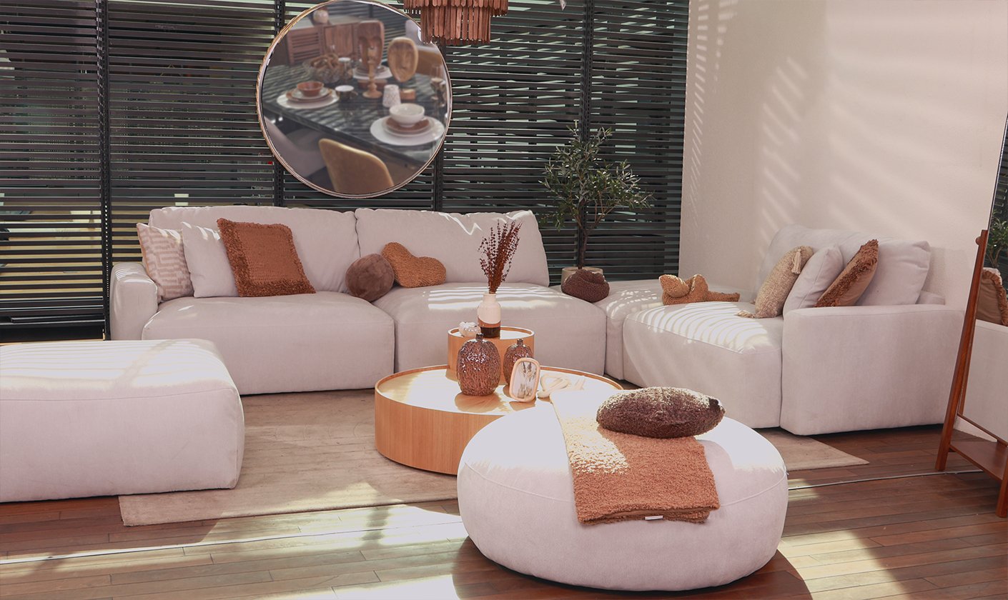 Modern neutral living room with upholstered sofas, wooden furniture, and warm decorative accents.