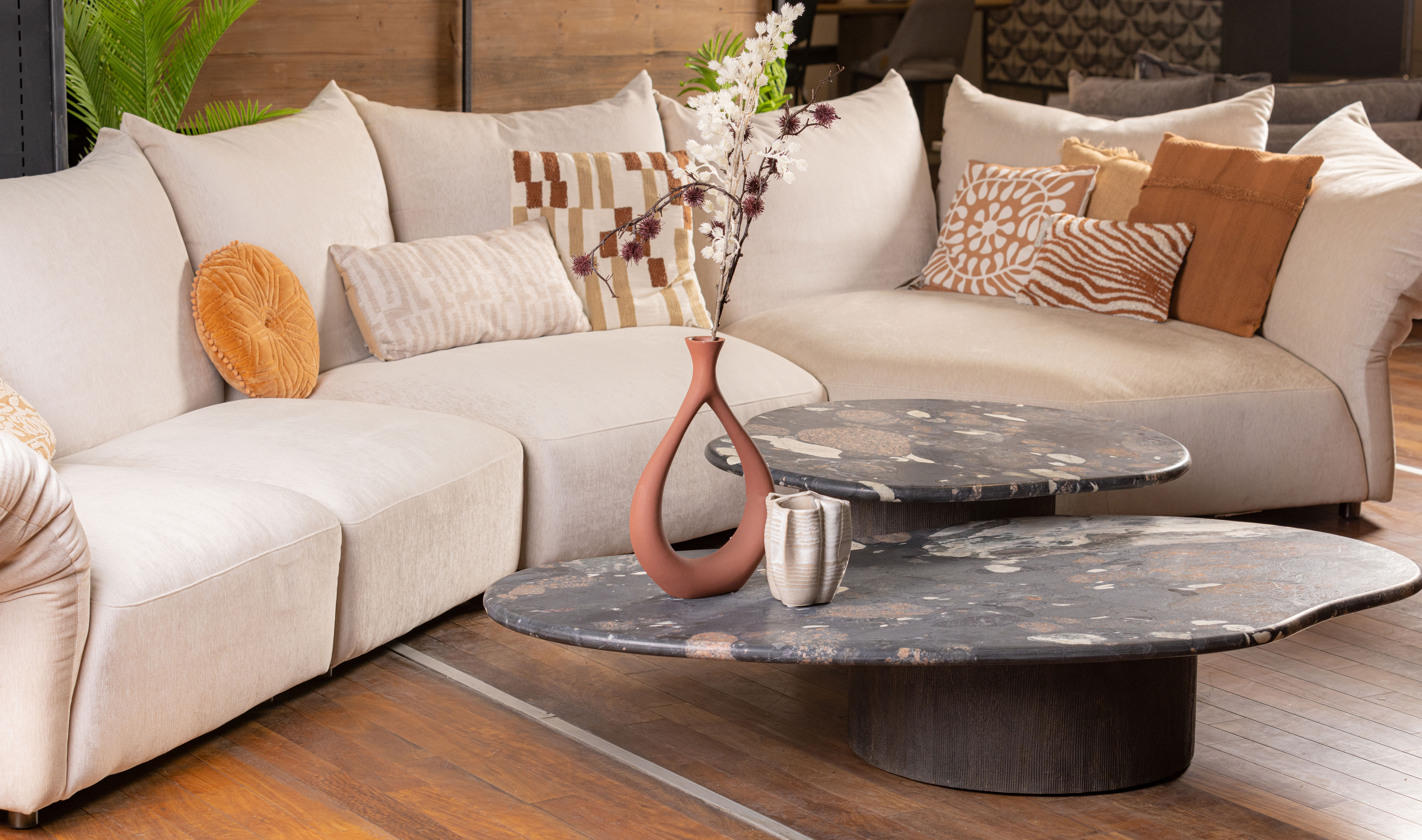 Contemporary living space styled with warm-toned d&eacute;cor and marble coffee table.
