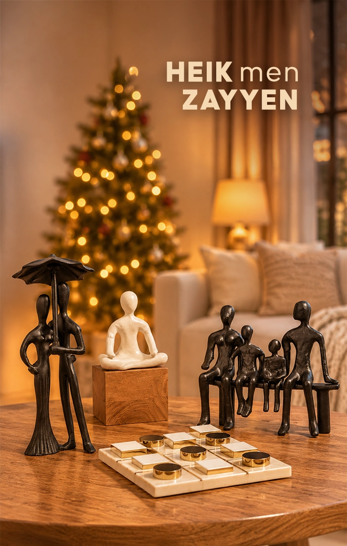 Elegant home d&eacute;cor accessories displayed on a wooden table, featuring a textured beige table lamp, decorative mirror, marble board game, white abstract sculpture, and black figurine in a bright modern living room.