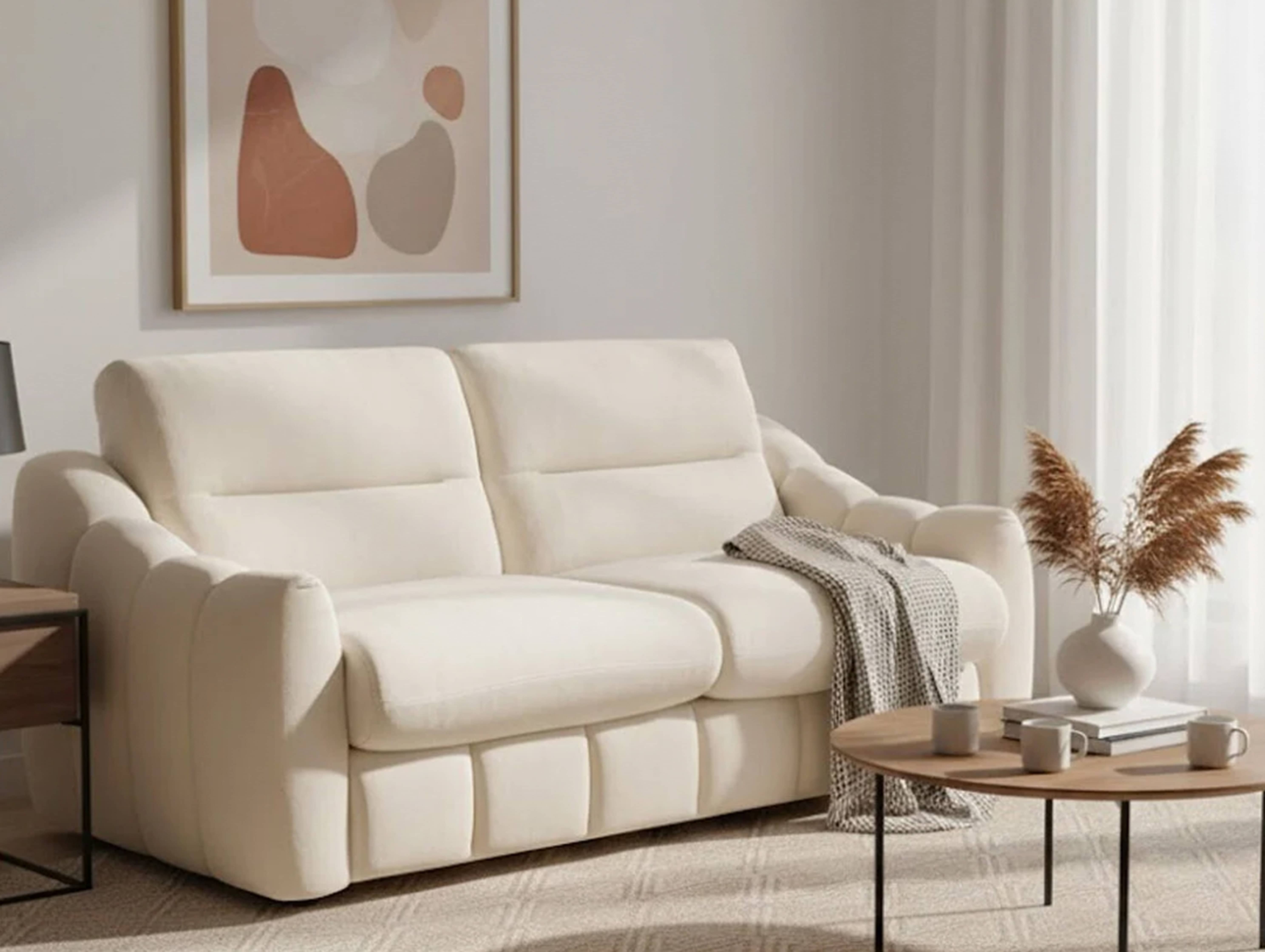 Neutral living room with a soft upholstered sofa styled with cushions and a coffee table.