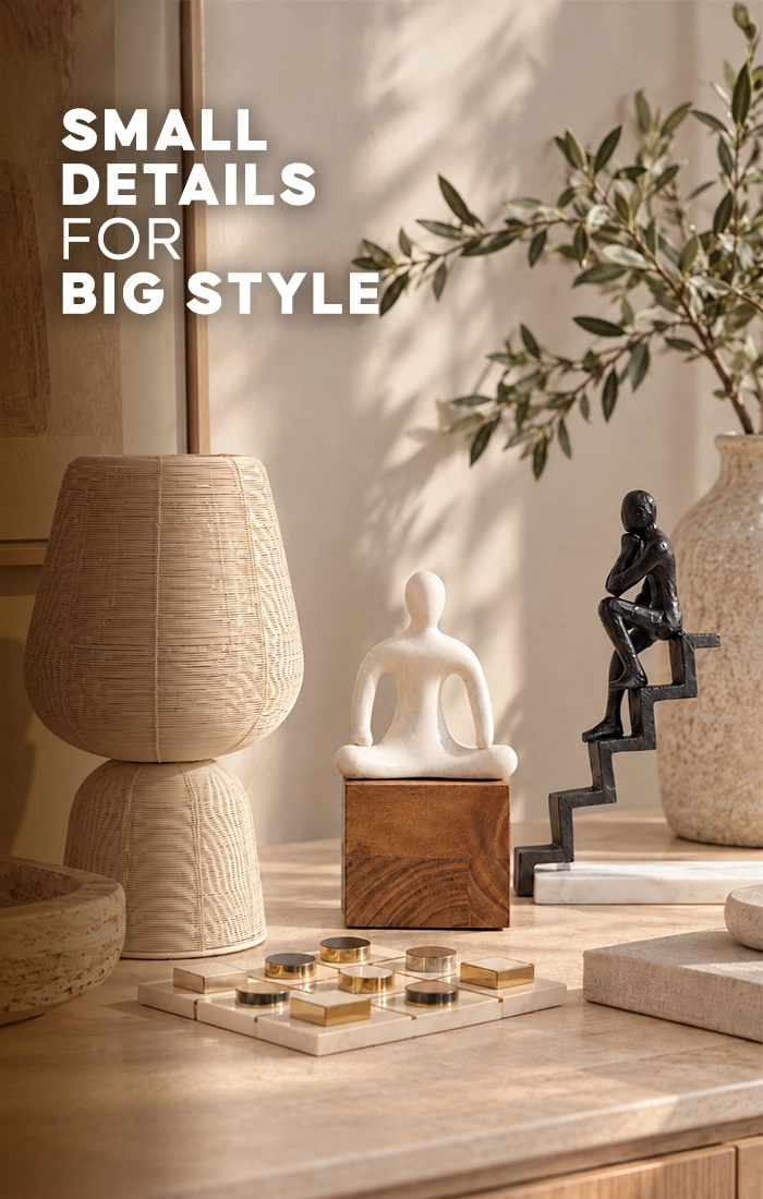 Elegant home d&eacute;cor accessories displayed on a wooden table, featuring a textured beige table lamp, decorative mirror, marble board game, white abstract sculpture, and black figurine in a bright modern living room.