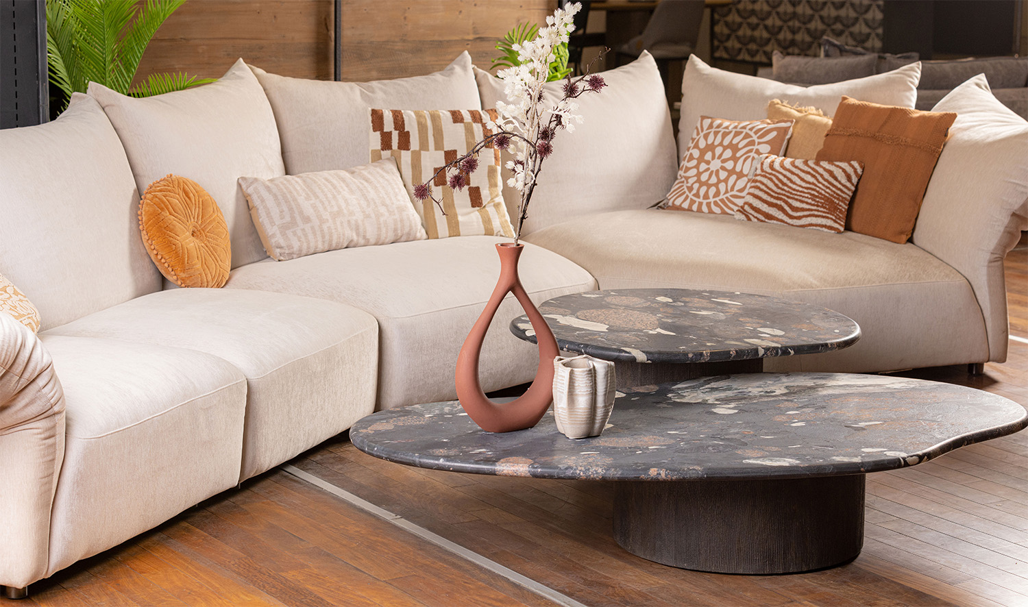 Contemporary living space styled with warm-toned d&eacute;cor and marble coffee table.